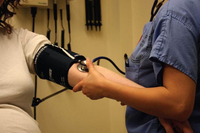 Someone having their blood pressure taken with a cuff and stethoscope