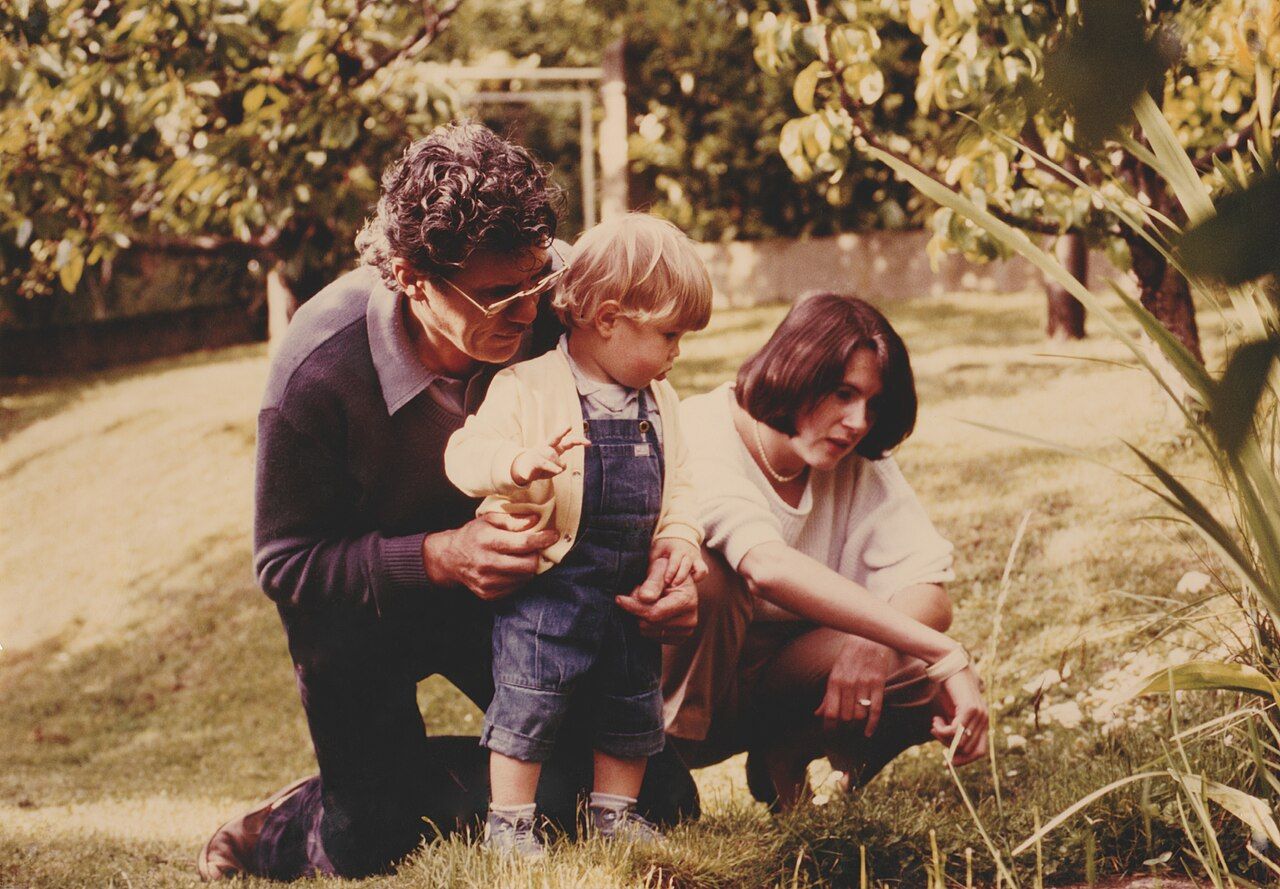 Three generations in a garden, a child, a middle-aged parent, and a grandparent