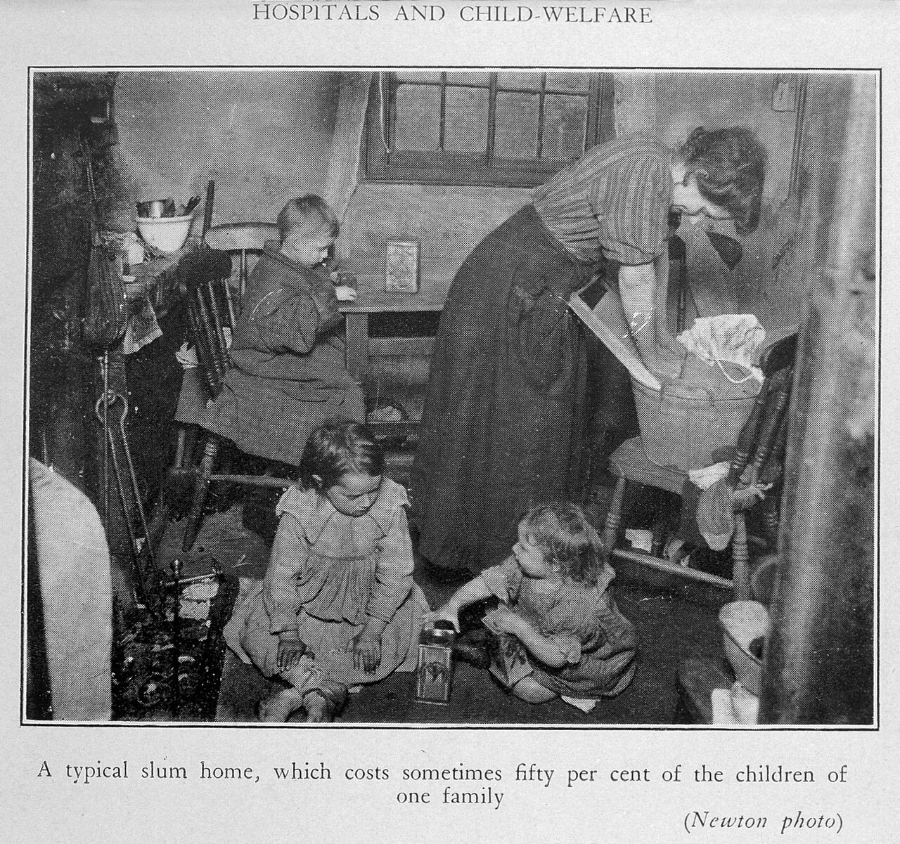 A mother with three children inside a small slum dwelling